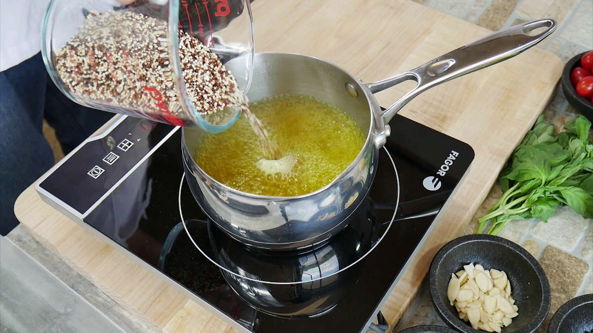 Adding red quinoa to crab stock. The crab stock is a golden yellow color from the saffron, which looks beautiful.