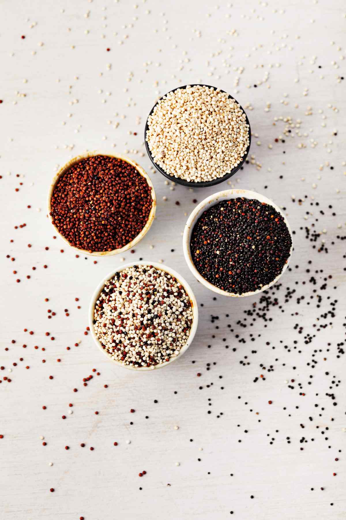 Multiple colors of quinoa on white background. Quinoa colors of red, white, black, tri-color.