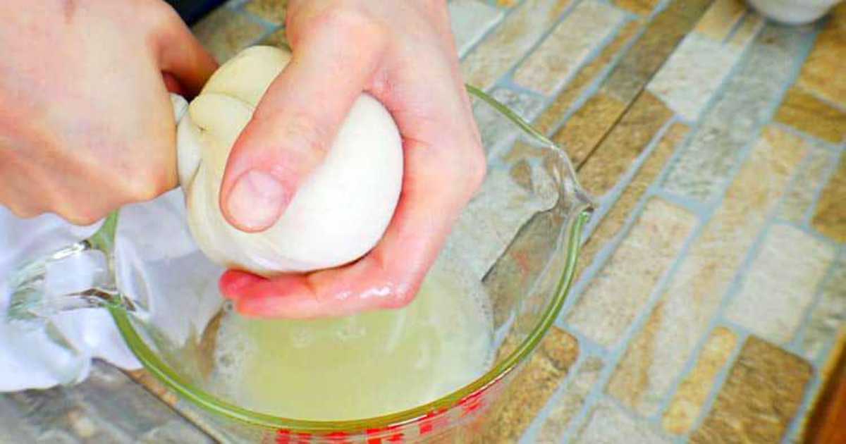 Using a kitchen towel to remove all the excess water within the cooked cauliflower.