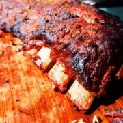 Instant Pot ribs fresh off smoker on wooden cutting board.