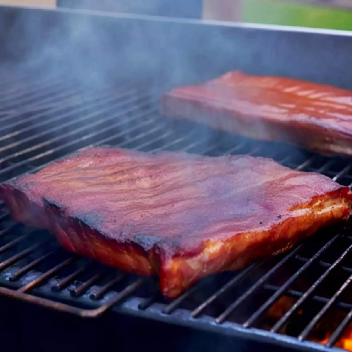 Homemade bacon smoking on the grill.