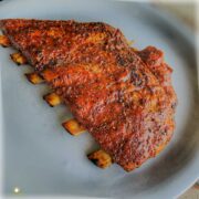 Sliced sous vide ribs on a white plate beautifully golden brown and caramelized with BBQ sauce