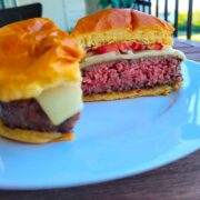 sous vide burger on white plate sliced in half to show the cooked burger