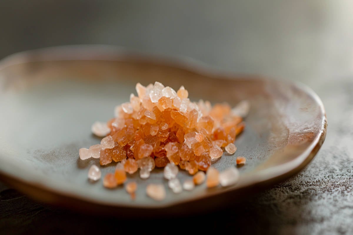 Coarse Himalayan Sea Salt on plate. You can see the colors of pink from the minerals within the salt.