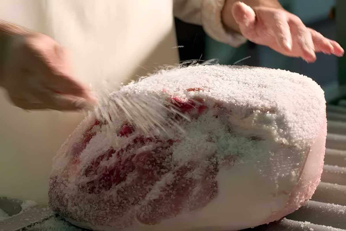 Prosciutto di Parma preparing with curing salt.