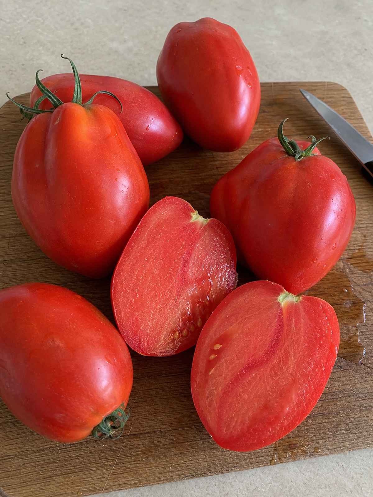 Amish Paste tomatoes with one sliced open to show thick flesh for sauce