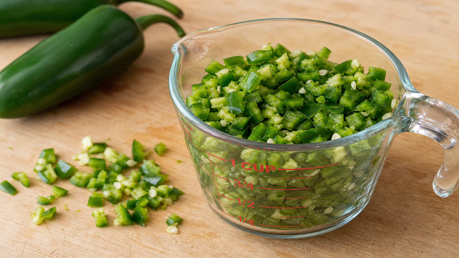 Chopped jalapenos in a one cup measuring cup