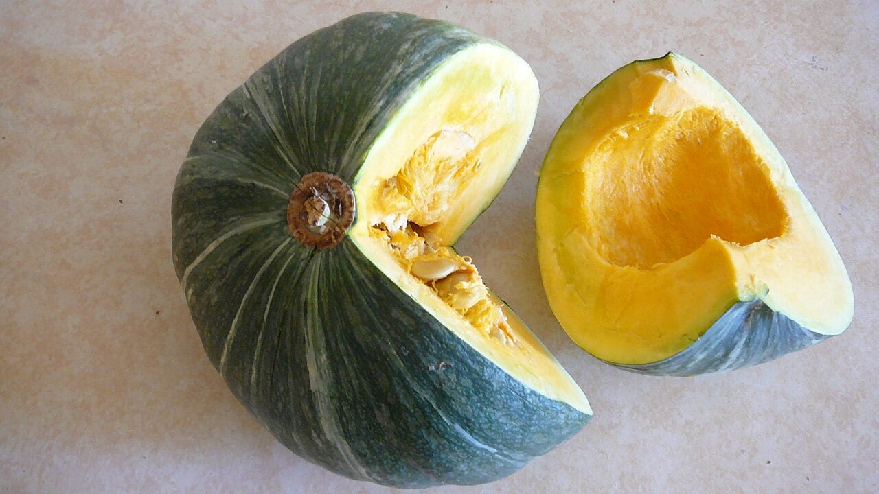 Kabocha squash cut open showing orange flesh and seeds